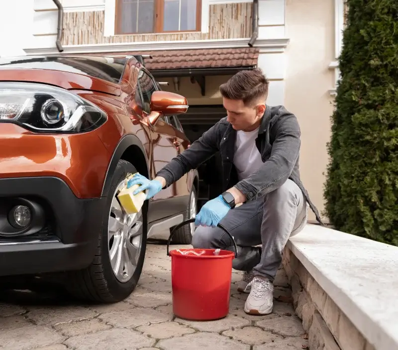 Lavage auto à domicile Caniac-du-Causse : professionnel intervenant sur un véhicule